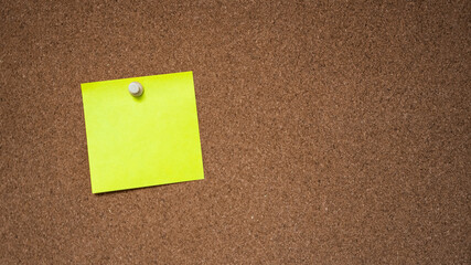 yellow note tacked to a corkboard 
