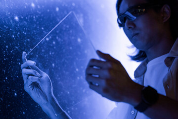 Researcher using a transparent digital tablet screen futuristic technology