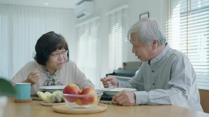 Attractive young senior asian citizen couple happy sit and talk, eat soup for healthy nutrition breakfast meal on dining table at home in morning in routine lifestyle in old asian people concept. - Powered by Adobe