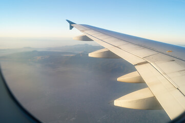 Fototapeta na wymiar ventanilla de avion, alas y niebla en la mañana sobre mexico