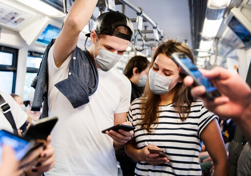 Couple Wearing Mask On The Train While Traveling On Public Transportation In The New Normal