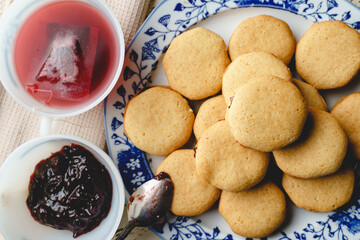 Homemade cookies with marmalade or fruit plum jam in a plate - close up top view baked sweet food traditional recipe - healthy eating concept