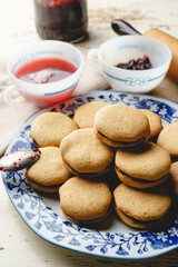 Homemade cookies with marmalade or fruit plum jam in a plate - close up front view baked sweet food traditional recipe - healthy eating concept