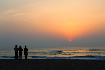 Fototapeta premium group of people on the beach in sunset.