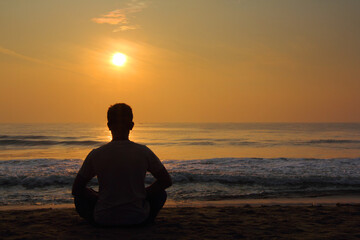 silhouette of person sitting on the beach