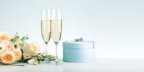Happy Valentine's Day. Romantic composition design, Two glasses of champagne wine with gift bow and bouquet of roses on the table. Banner. © Sergey