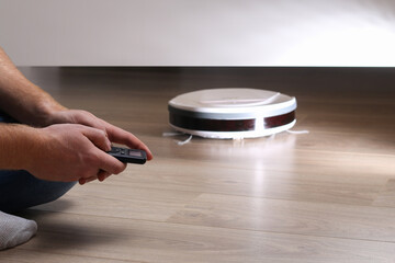 The robot vacuum cleaner cleans under the bed.
