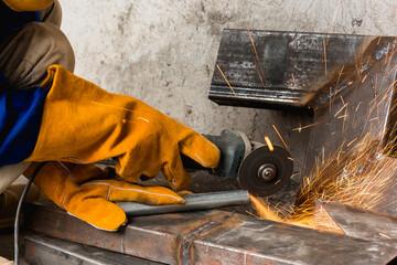 Closeup of a angle grinder being used to cut a notch inside a steel pipe. At a construction site.