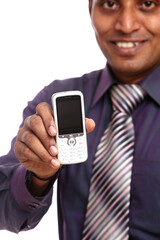Indian  young businessman posing with mobile phone on white background.