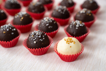 Dark and white chocolate coated almond London cookies in red paper cup