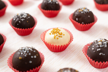Dark and white chocolate coated almond London cookies in red paper cup