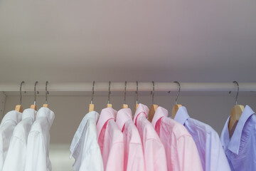 Clothes hanger in the wardrobe with white and pink shirt ready wear to work