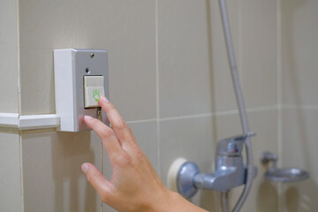 Patient hand pressing the emergency call button in the bathroom. Pressing nurse emergency call for...