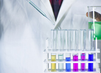 Scientist taking color solution in a test tube