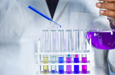Scientist taking color solution in a test tube