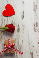 Wrapped gift with ribbon, red heart and rose for Valentines Day. Place for text