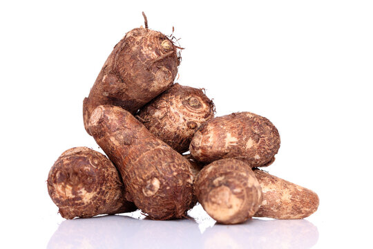 Fresh whole taro root over white background
