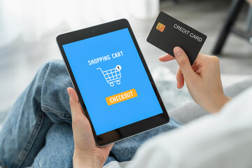 Young woman holding tablet and online shopping with payment credit card on internet at home.