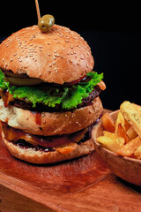 
close-up of double burger with potatoes meat lettuce tomato and bread