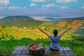 Women tourists sit and breathe fresh morning air and delicious food.