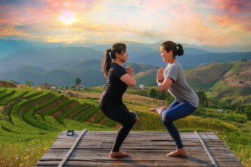 The lifestyle of a woman practicing meditation and outdoor Zen-energy yoga on a bridge in the evening amid mountain nature. With sunset