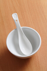 White bowl and spoon on table.