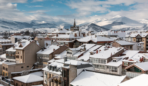 Paisaje nevado de la ciudad de Reinosa con los tejados de sus edificios blancos y las monta&ntilde;as cubiertas al fondo