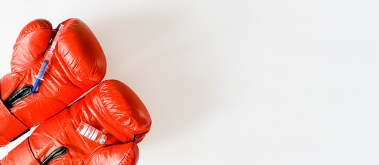 Syringe and dope ampoule on red boxing gloves. Banner, copy space. Doping, pharmacology and sports...