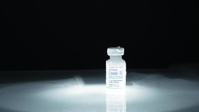 Researcher's hand pick up frozen cold Vaccine vial for Covid-19 with mRNA technology stored in subzero low temperature -70 celsius. Effective thermal controlled for global distribution conditions.