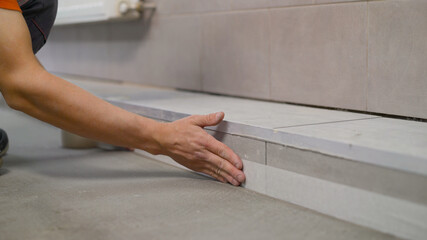 The craftsman glues the skirting boards to prepare for the renovation. Processing corners before...