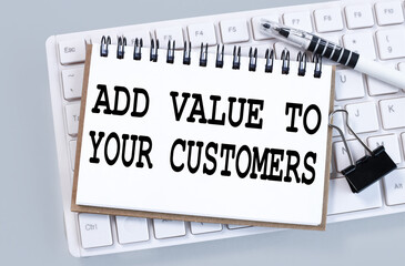 ADD VALUE TO YOUR CUSTOMERS. text on white paper on white keyboard on gray background