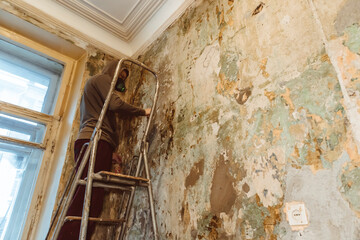 cleaning grinding the walls from wallpaper worker painter mask