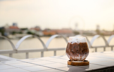 Chilled iced chocolate cocoa in glasses on the balcony by the river. Copy space