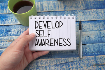 Develop self awareness, text words typography written on book against wooden background, life and...