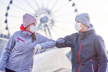 Adult couple jogging in the city in masks during lockdown
