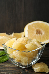 Bowl with ripe pomelo fruit slices on wooden table