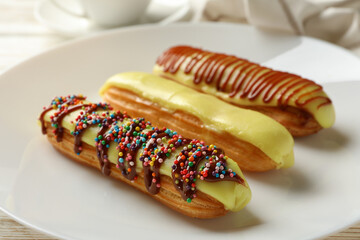 Tasty eclairs with custard and delicious topping, close up