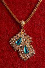 Gold Necklaces on textured red background.