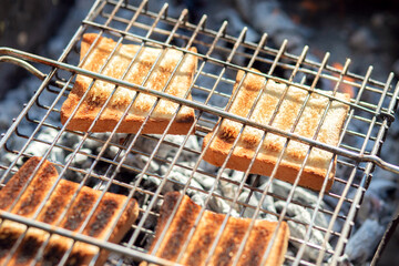 Toast is fried over charcoal. BBQ grill. Making crispy croutons over the fire