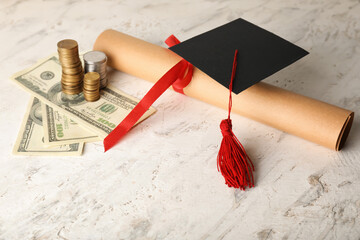 Diploma with graduation hat and money on light background