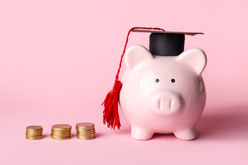 Piggy bank with graduation hat and coins on color background