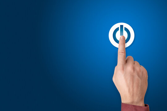 Hand of the businessman pressing power button. Start up business concept. Arm press on button on-off. Blue background, copy space