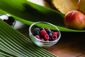 Close up bowl with berries on leaves