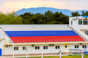 Empty stands on the stadium outdoor. Empty tribune due to pandemic Covid-19. Concept of pandemic life , empty stadiums, distance from viewers, safety