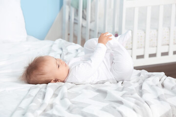 Cute little baby lying on bed at home