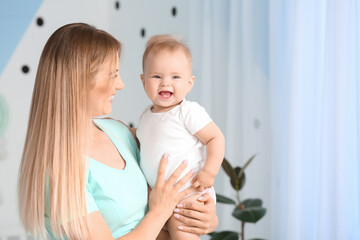 Happy mother with cute little baby at home