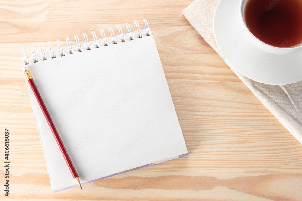 Poster mock up blank notepad with pen, notebook and tea cup on wooden table. top view notebook with blank p
