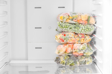 Plastic bags with frozen vegetables in refrigerator