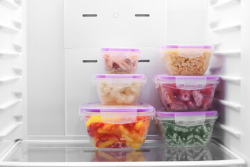 Containers with frozen vegetables in refrigerator