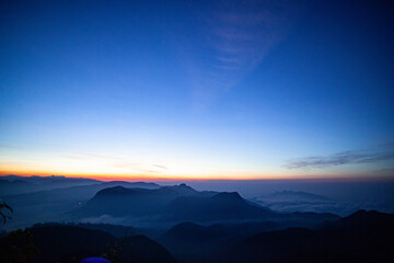 Sunrise over the mountains standing in fog on the island of Sri Lanka.